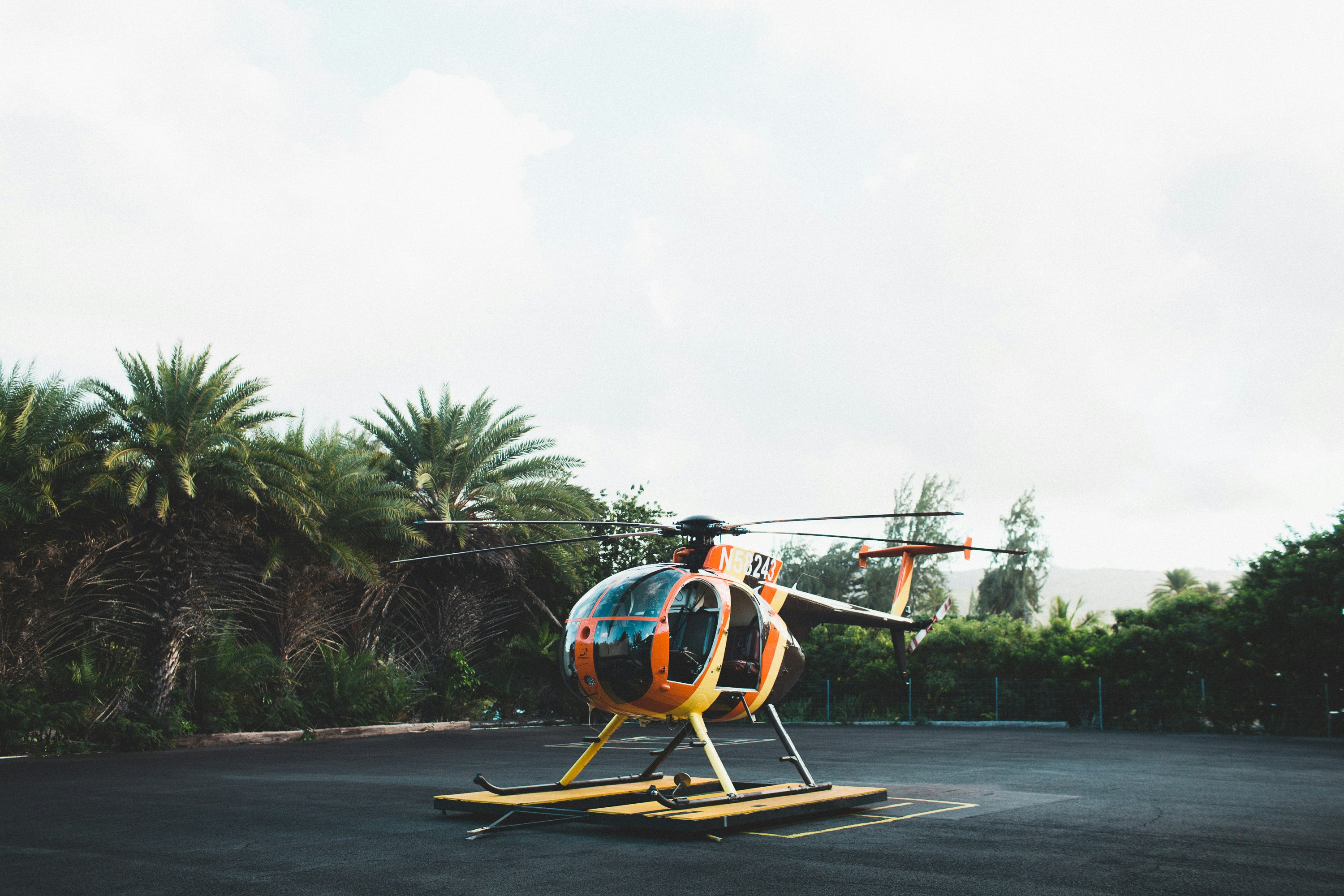 orange and yellow helicopter on ground at daytime